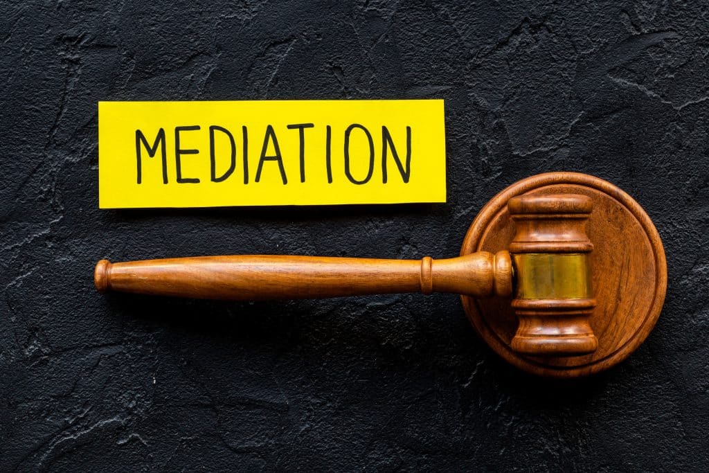 Wooden gavel beside a note that reads Mediation