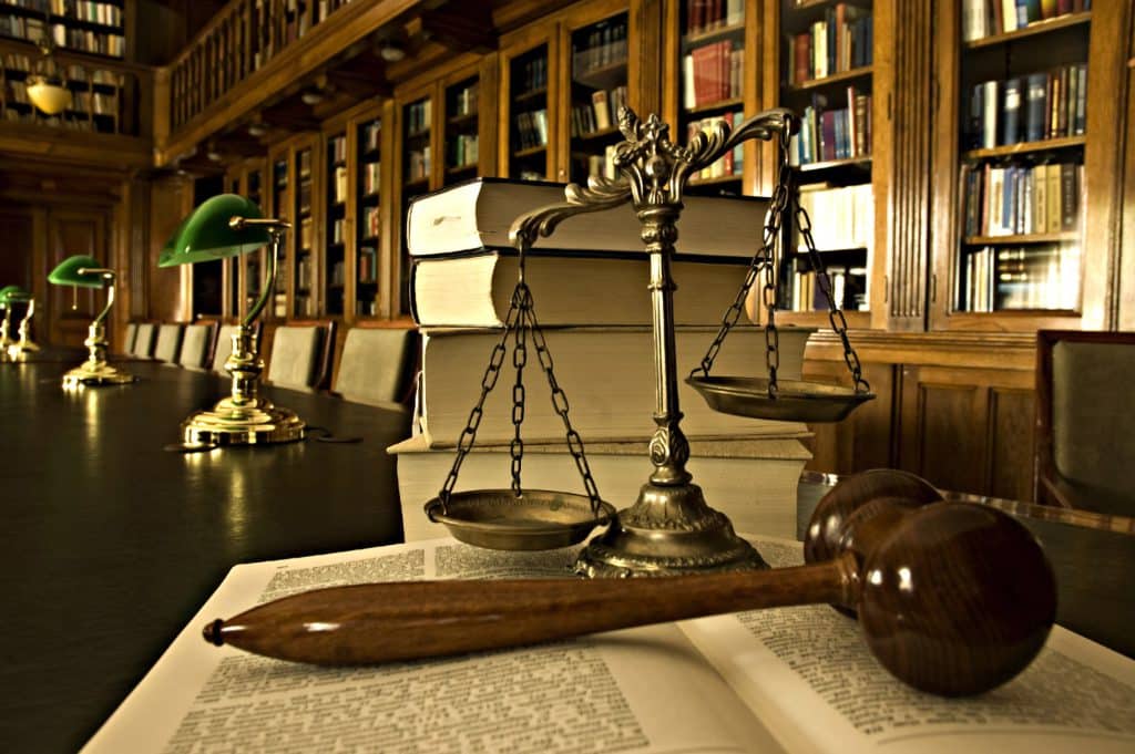 Scales of justice, a gavel and law books in a law library
